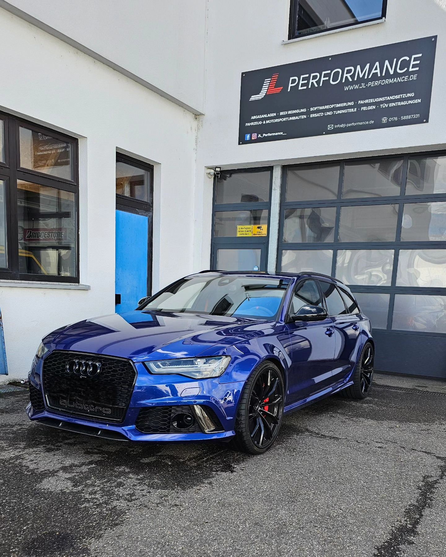 Blauer Audi RS6 Avant vor der Werkstatt