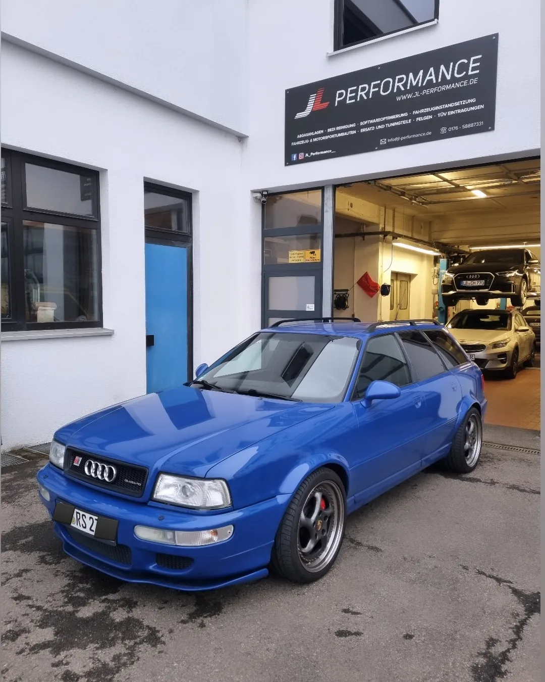 Blauer Audi RS2 Avant vor der Werkstatt