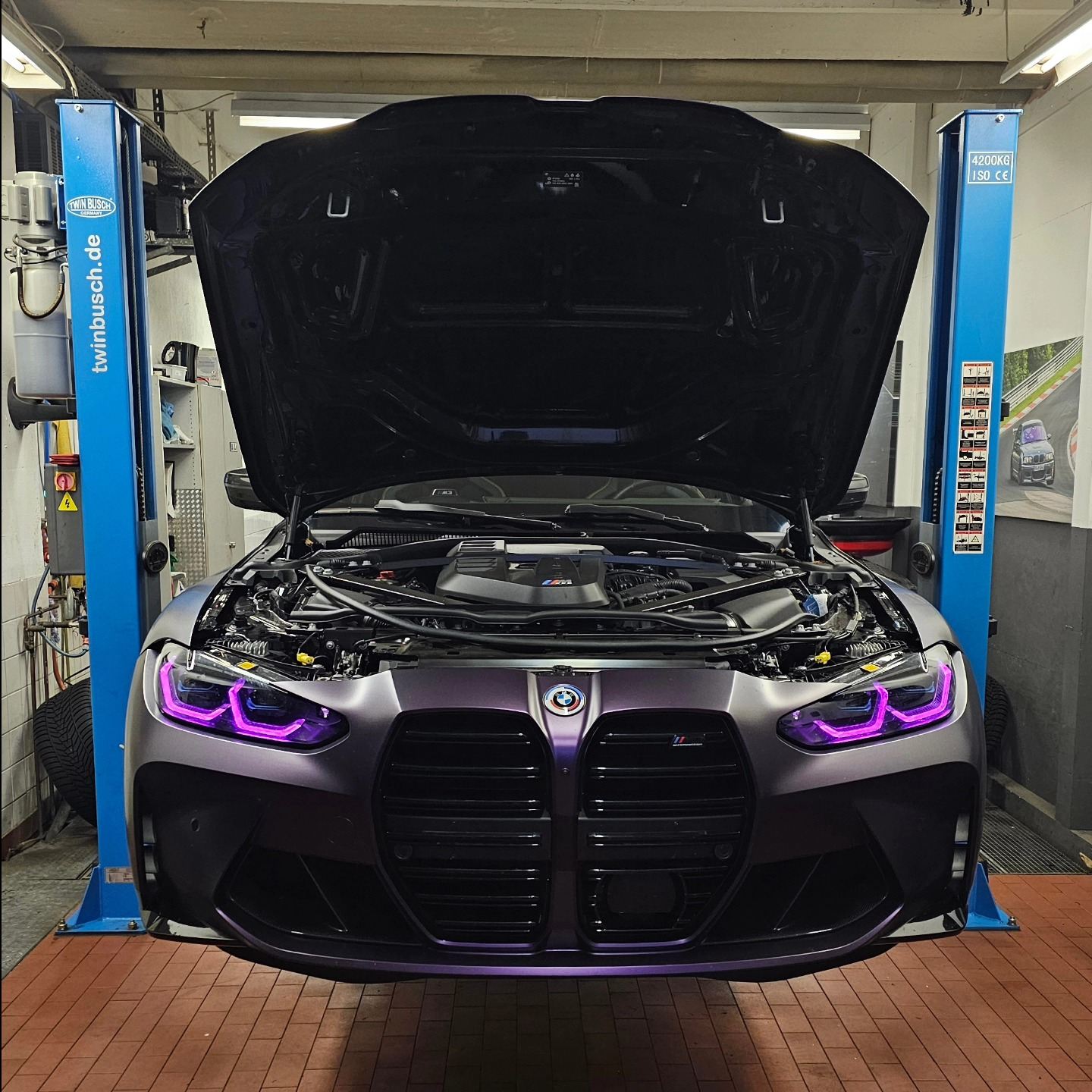 BMW M4 auf der Hebebühne mit geöffneter Motorhaube