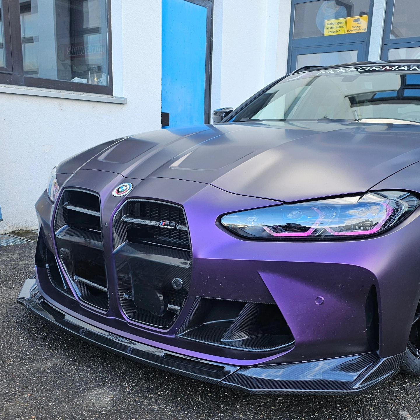 BMW M4 mit violetter Folierung und Carbon-Frontlippe